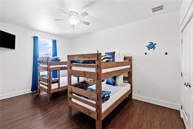 bedroom featuring visible vents, baseboards, a ceiling fan, and wood finished floors