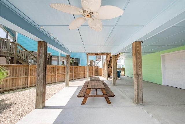 view of patio featuring fence and stairs