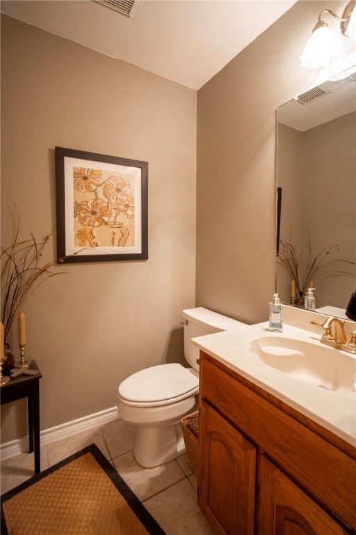 bathroom with toilet, vanity, and tile patterned flooring