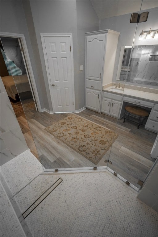 bathroom featuring walk in shower, hardwood / wood-style floors, and vanity