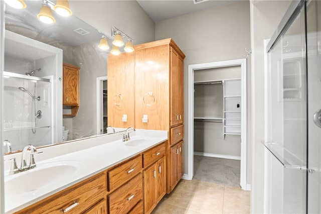 bathroom featuring toilet, vanity, tile patterned flooring, and a shower with shower door