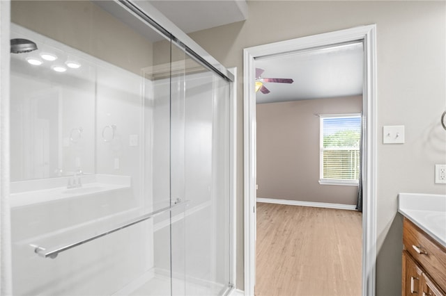 bathroom featuring vanity, wood-type flooring, a shower with door, and ceiling fan