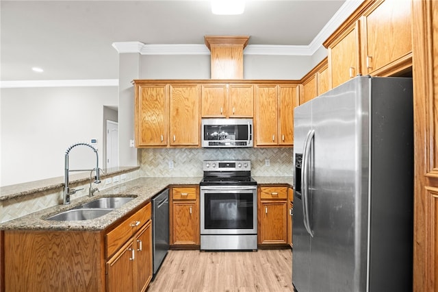 kitchen with stainless steel appliances, sink, kitchen peninsula, ornamental molding, and light wood-type flooring