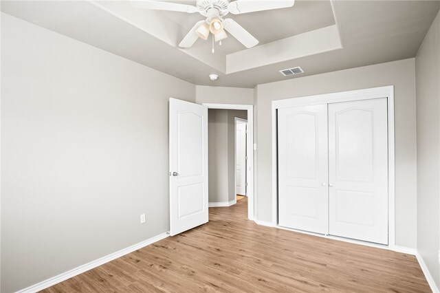 unfurnished bedroom featuring a closet, light wood-type flooring, and ceiling fan