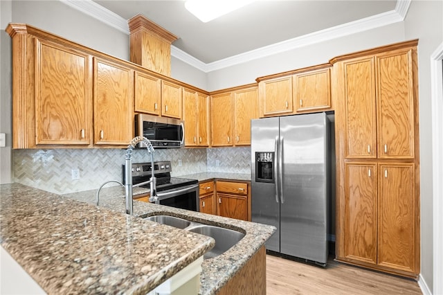 kitchen with appliances with stainless steel finishes, light stone counters, crown molding, and light hardwood / wood-style flooring