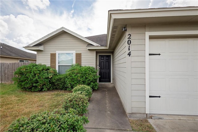 doorway to property featuring a garage and a yard