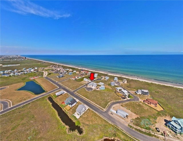 bird's eye view featuring a water view and a beach view