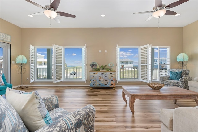 living room with ceiling fan, light hardwood / wood-style floors, and a healthy amount of sunlight