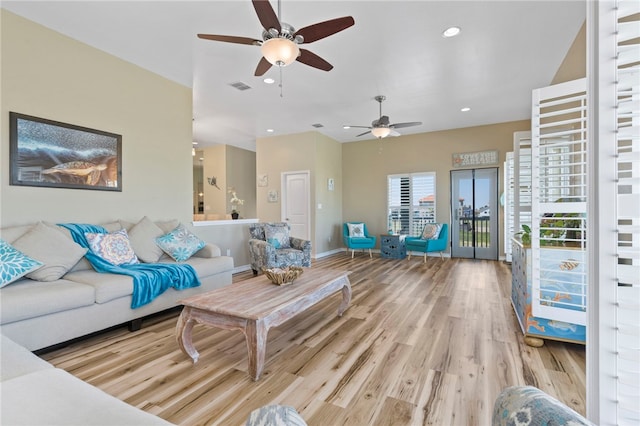 living room featuring ceiling fan and light hardwood / wood-style flooring