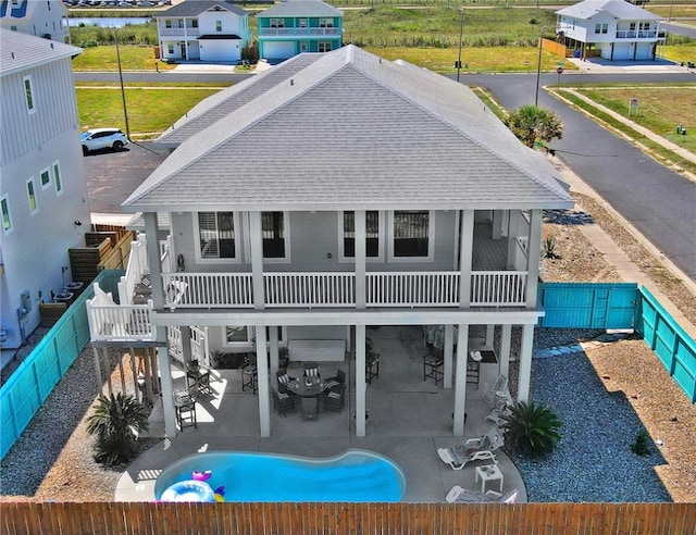 back of property with a sunroom and a patio area