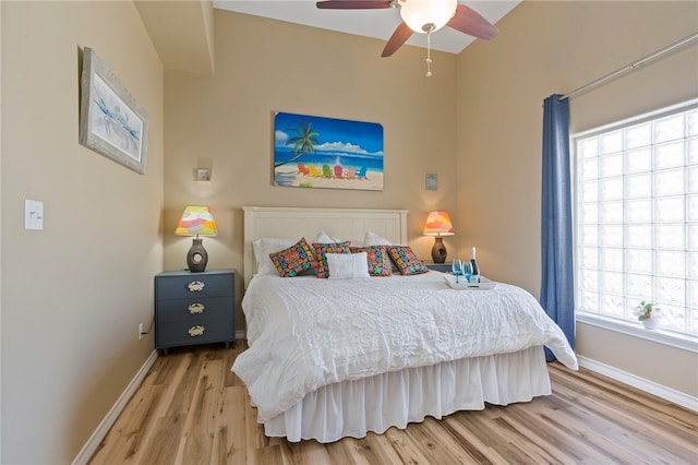 bedroom featuring light wood-type flooring, multiple windows, and ceiling fan