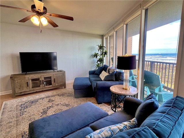 living room with a water view, ceiling fan, and light hardwood / wood-style flooring