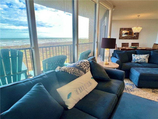 living room featuring a wealth of natural light, a water view, carpet floors, and a notable chandelier