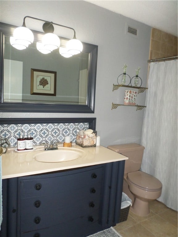 bathroom featuring curtained shower, tile patterned flooring, vanity, and toilet