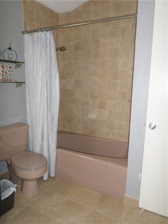 bathroom with tile patterned floors, shower / bath combo, and toilet