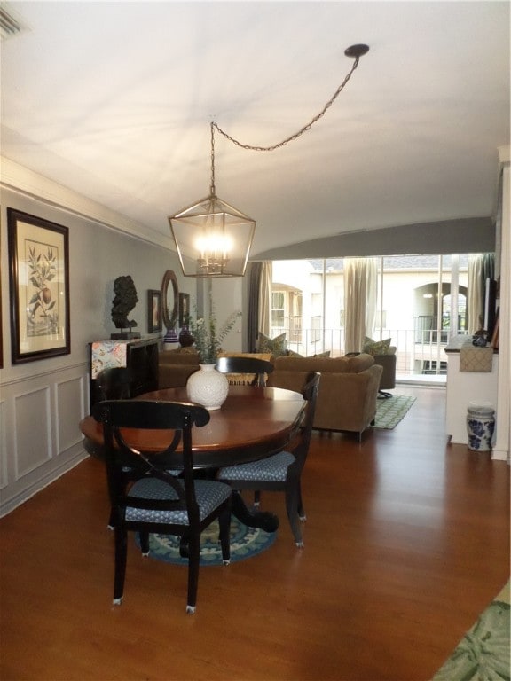 dining room with dark wood-type flooring and a notable chandelier