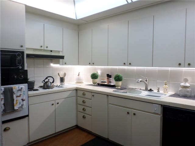 kitchen with black appliances, white cabinetry, sink, and backsplash