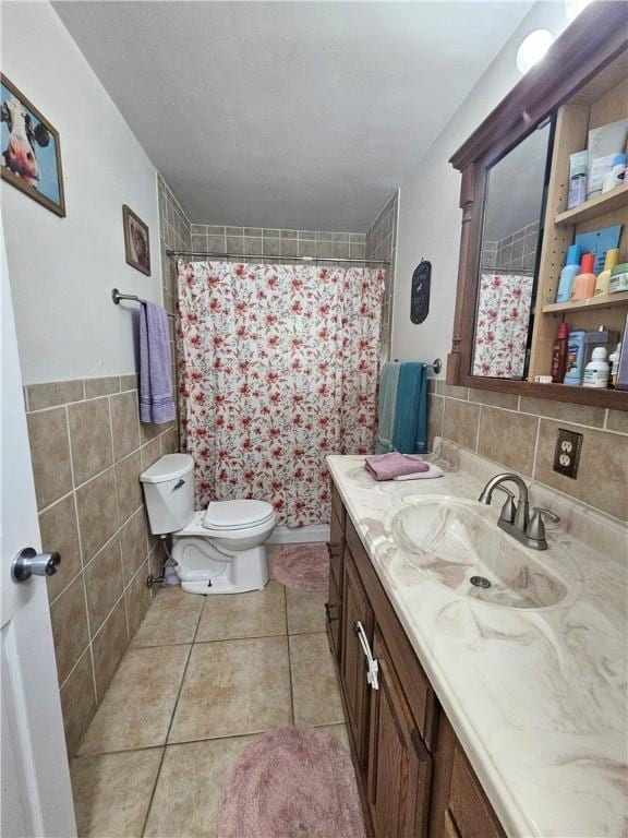bathroom featuring vanity, toilet, tile patterned floors, tile walls, and curtained shower