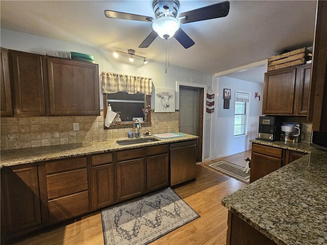 kitchen with ceiling fan, backsplash, dishwasher, a sink, and stone counters