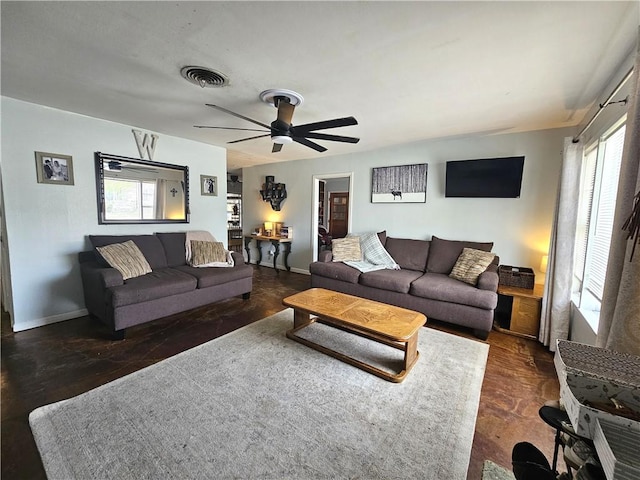 living room featuring visible vents, baseboards, and ceiling fan