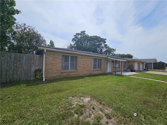 ranch-style home with brick siding, fence, a front lawn, concrete driveway, and an attached garage