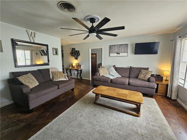 living area with ceiling fan, visible vents, and baseboards