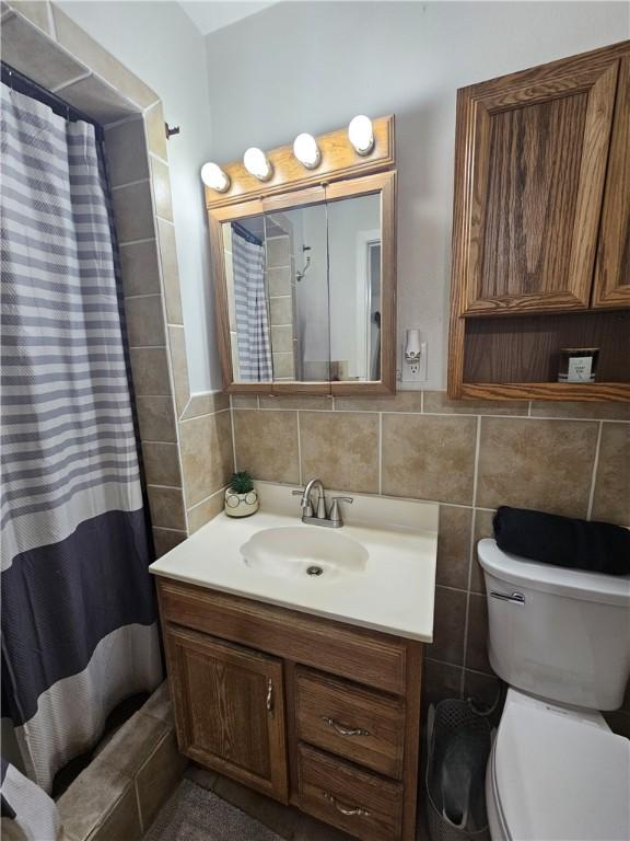 full bath with tile walls, vanity, toilet, and a shower with shower curtain