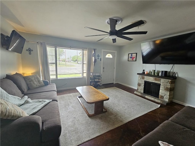 living area with ceiling fan, baseboards, and a fireplace