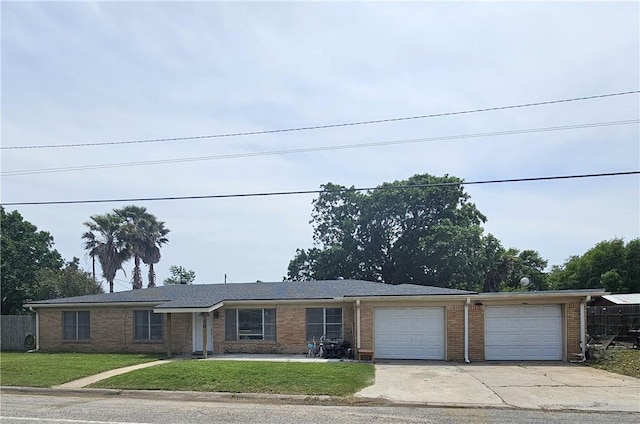 ranch-style house featuring a garage, concrete driveway, a front lawn, and brick siding