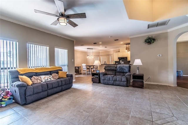 tiled living room featuring ceiling fan and ornamental molding