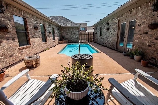 view of swimming pool with a patio area and french doors