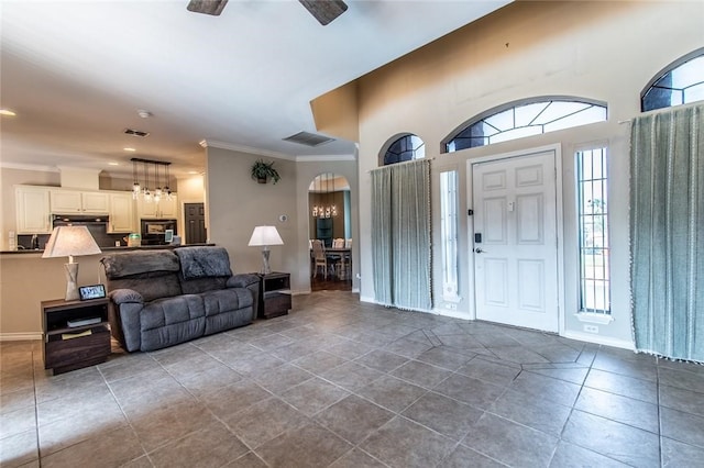 foyer with ceiling fan, tile patterned floors, and ornamental molding