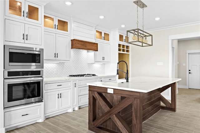 13942 Ketch St, Corpus Christi, TX 78418 - kitchen featuring appliances with stainless steel finishes, backsplash, light wood-style floors, pendant lighting, and crown molding
