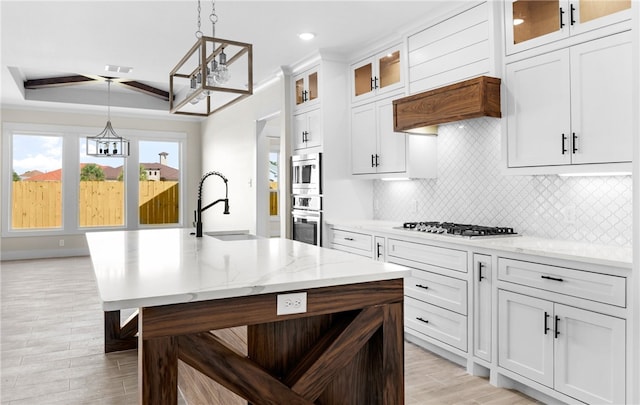 13942 Ketch St, Corpus Christi, TX 78418 - kitchen with appliances with stainless steel finishes, a chandelier, hanging light fixtures, decorative backsplash, and light wood finished floors