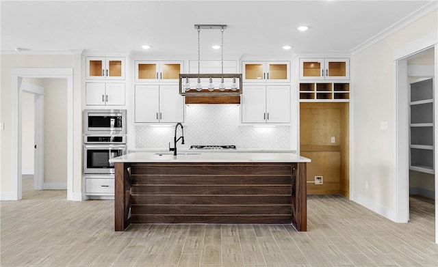 13942 Ketch St, Corpus Christi, TX 78418 - kitchen with appliances with stainless steel finishes, an island with sink, light countertops, backsplash, and white cabinetry