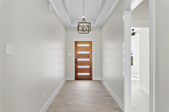 13942 Ketch St, Corpus Christi, TX 78418 - entryway with crown molding, light wood-style floors, a chandelier, and a tray ceiling