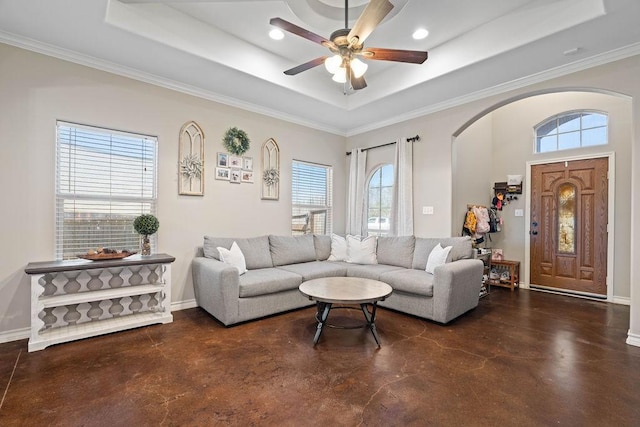 living room with ceiling fan, a healthy amount of sunlight, a raised ceiling, and ornamental molding