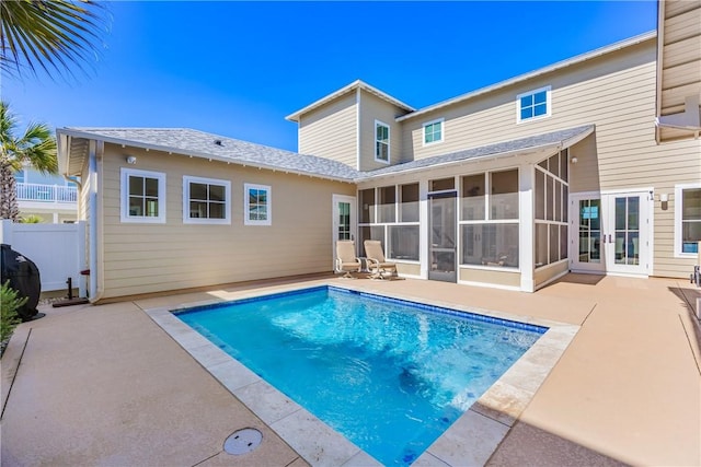 view of swimming pool with a fenced in pool, fence, a patio, and a sunroom