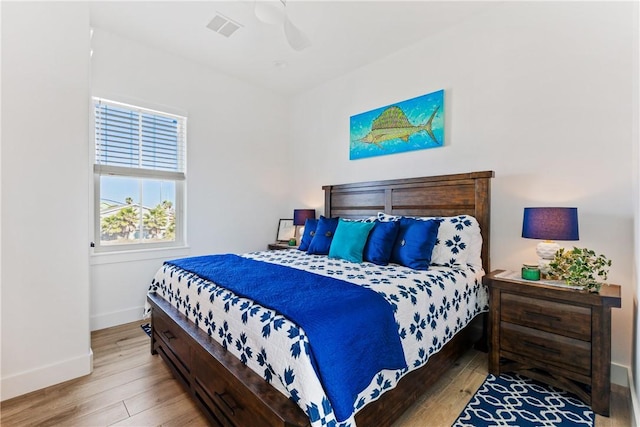 bedroom with visible vents, ceiling fan, baseboards, and wood finished floors