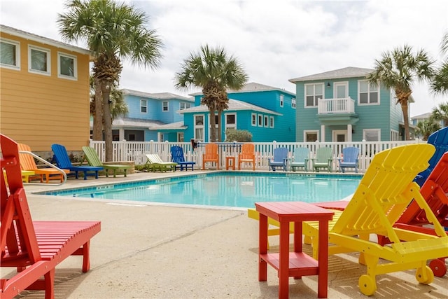 pool with a patio area, a residential view, and fence