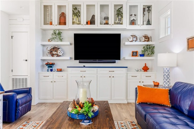 living area featuring light wood finished floors and visible vents