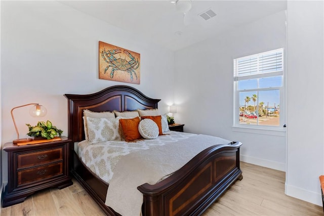 bedroom featuring light wood finished floors, visible vents, and baseboards