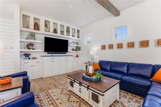 living area featuring beamed ceiling and light wood finished floors