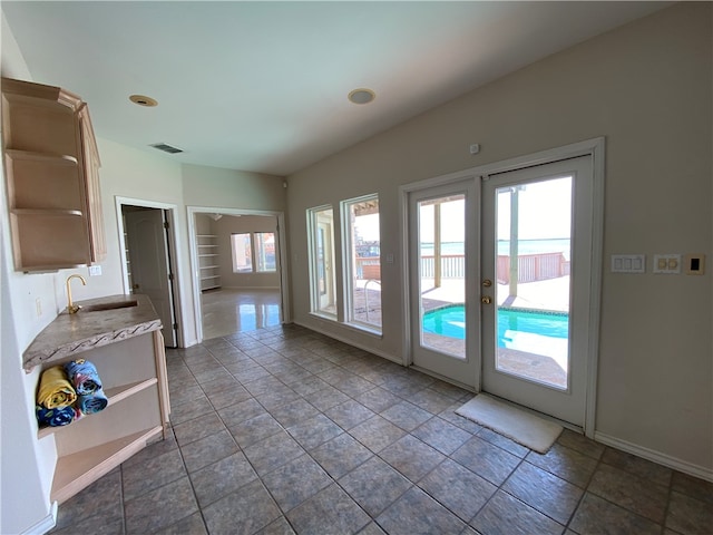 entryway with dark tile patterned flooring, sink, and french doors