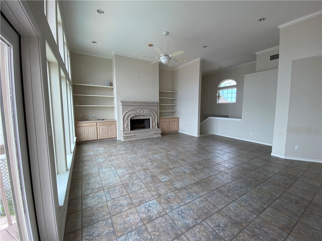 unfurnished living room with built in shelves, ceiling fan, and crown molding