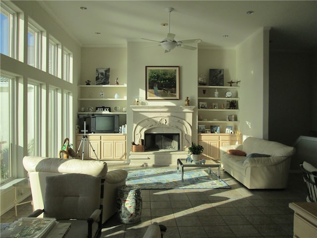 living room featuring ceiling fan, a healthy amount of sunlight, and crown molding