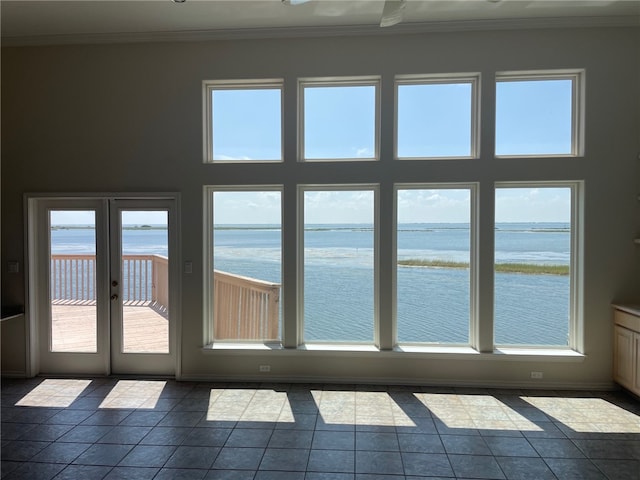 doorway to outside featuring tile patterned flooring, a water view, and crown molding