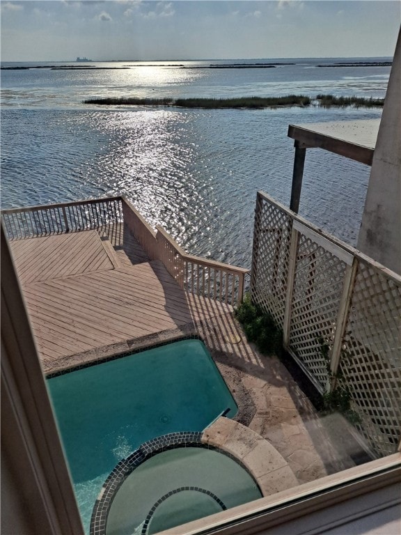 dock area featuring a water view and an in ground hot tub