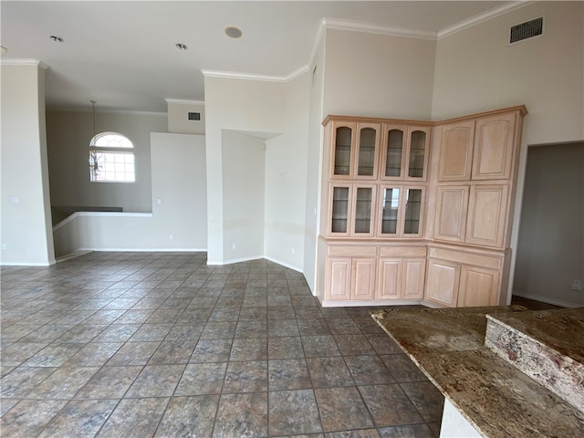 empty room featuring a high ceiling and crown molding