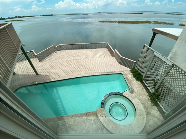 exterior space featuring a water view and a swimming pool with hot tub